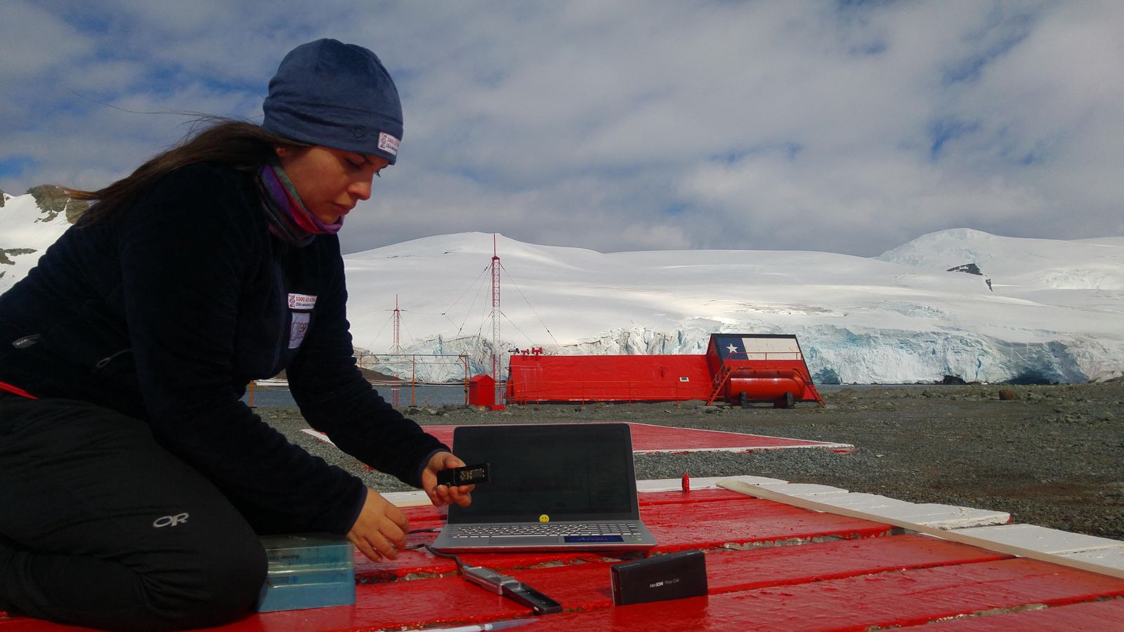 Una investigadora de la Universitat de Xile treballa en el portàtil mentre comprova material orgànic buscant un bacteri descobert a l'Antàrtida