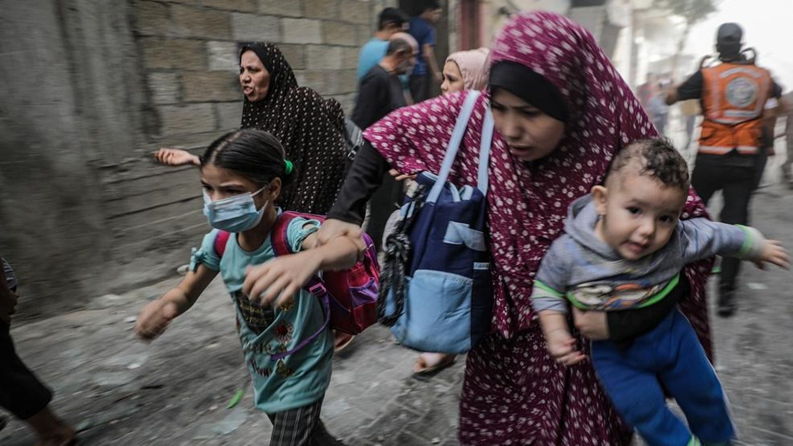 Una dona busca recer amb els fills durant un atac aeri a Gaza