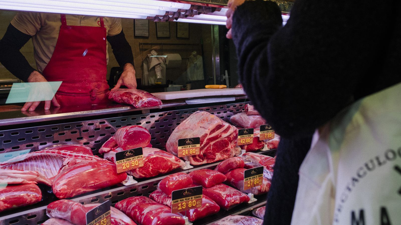 Una persona compra carn en un mercat