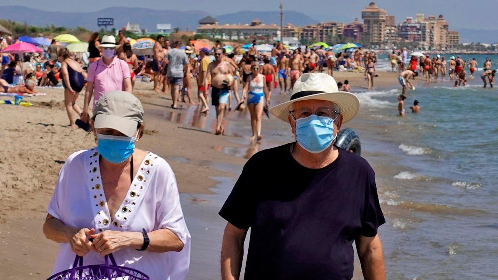 Dos persones passegen per la platja de la Patacona d'Alboraia protegits amb mascaretes