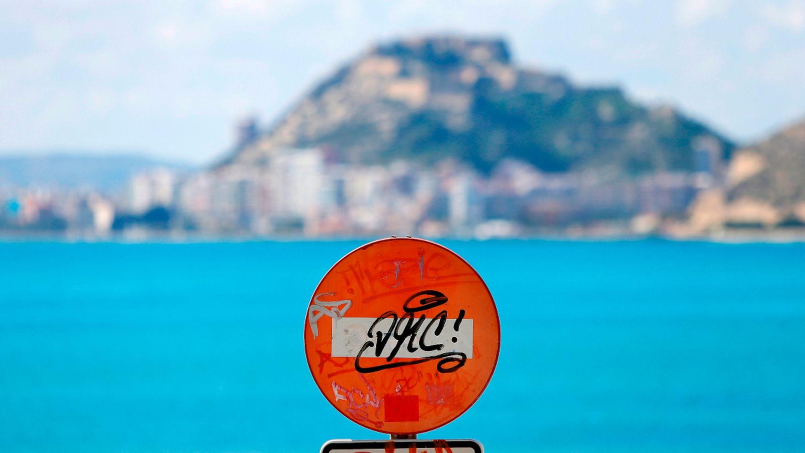 Un senyal de prohibit el pas, a l’entrada de la platja de l’Almadrava d’Alacant, amb el castell de Santa Bàrbera al fons, aquesta Setmana Santa