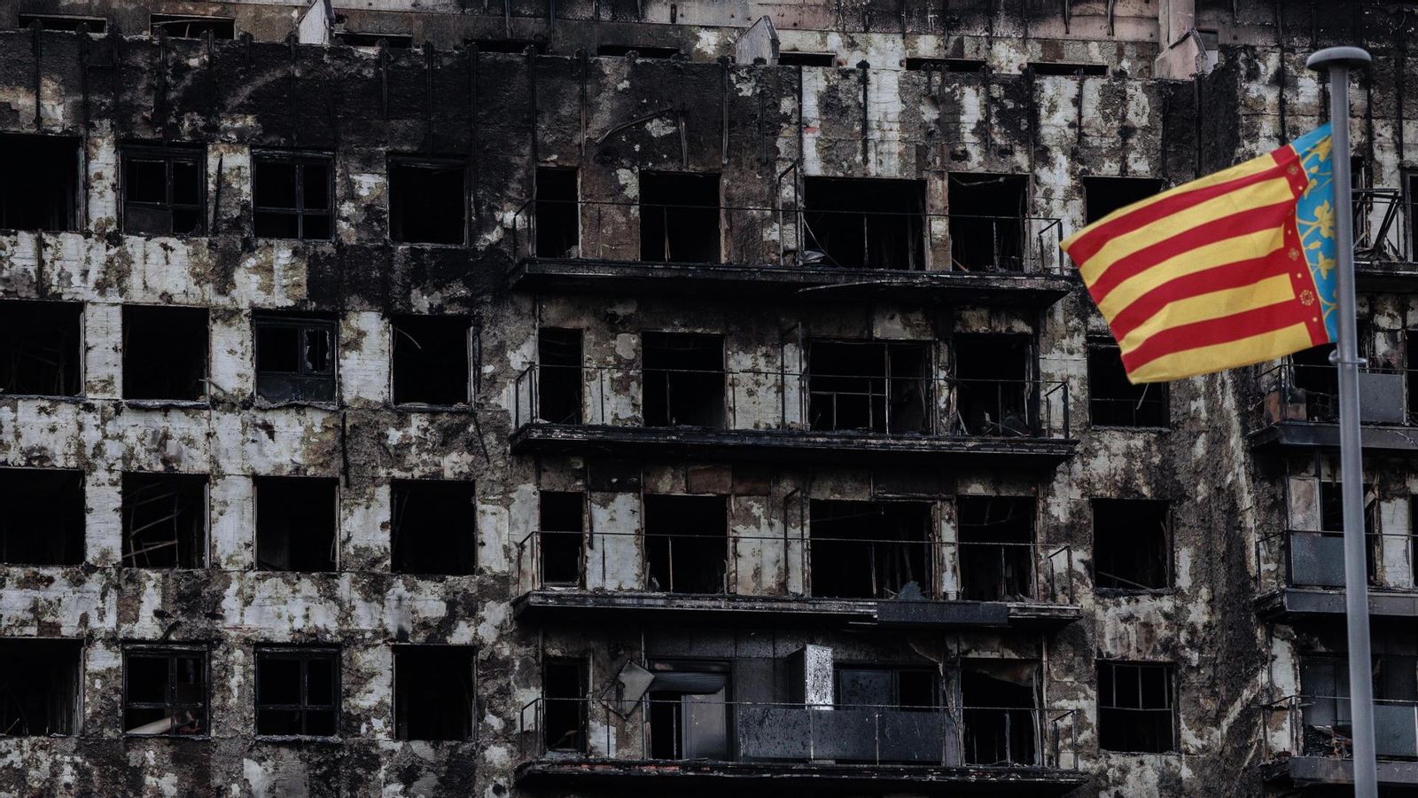 La senyera valenciana oneja davant de l'edifici cremat, aquest dimarts