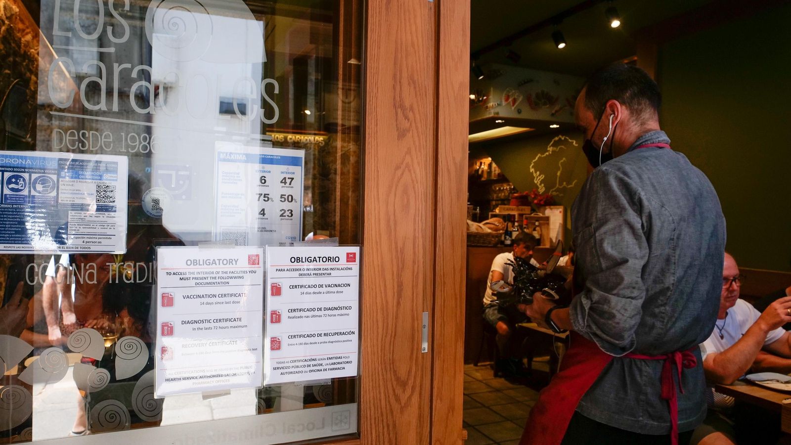 Entrada d'un restaurant amb els cartells que obliguen a complir la normativa vigent