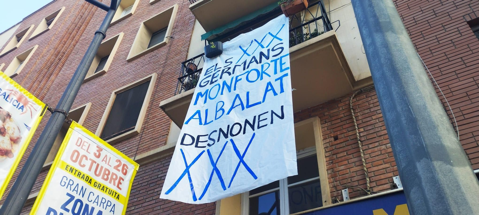 Pancarta al·lusiva als grans tenedors que han adquirit l'immoble