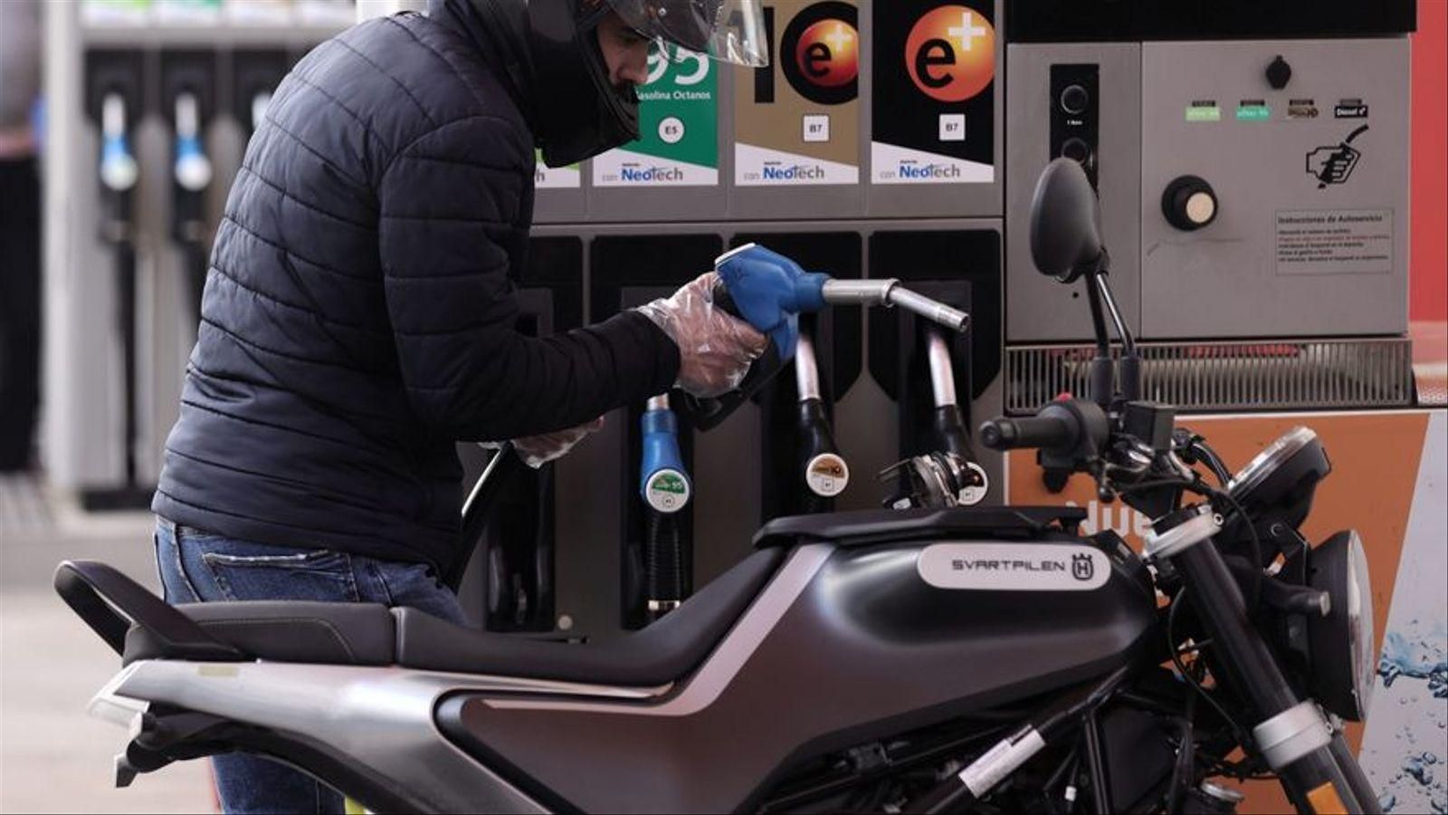 Un home reposta combustible en la seua moto / Europa Press