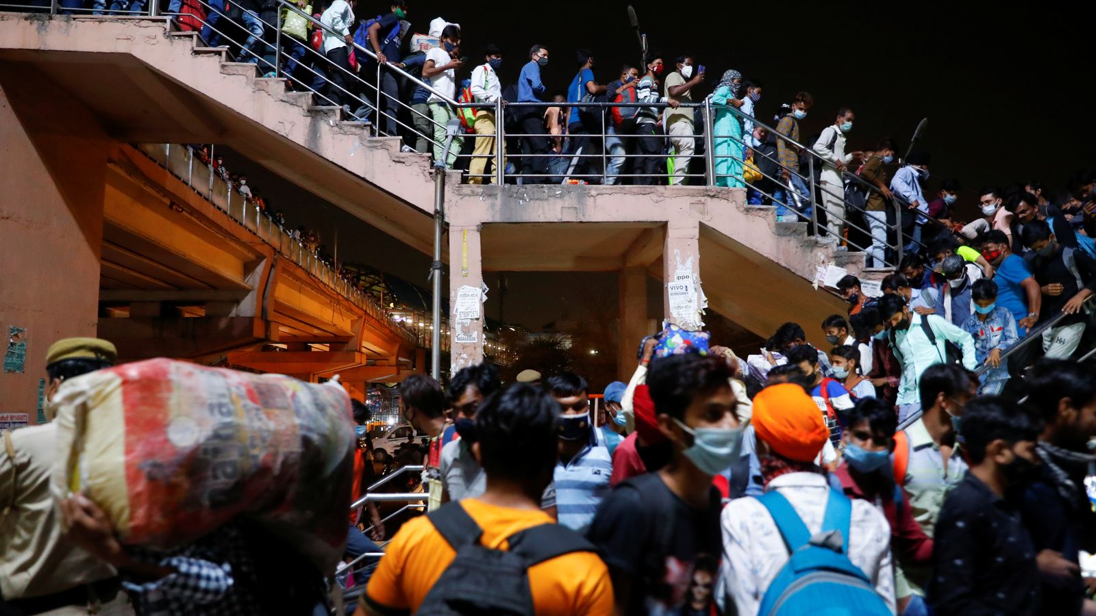 Milers de treballadors migrants han acudit en massa a estacions de tren i autobús per a escapar al confinament de Nueva Delhi, a l'Índia