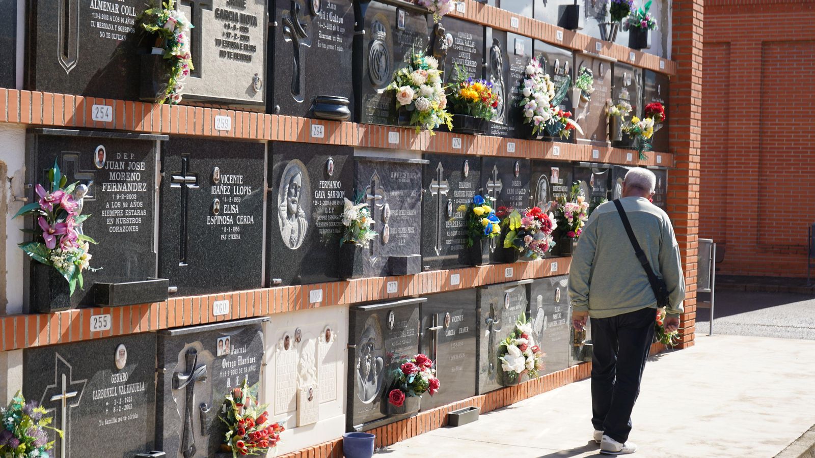 Un home avança per davant dels nínxols del cementeri de Gandia