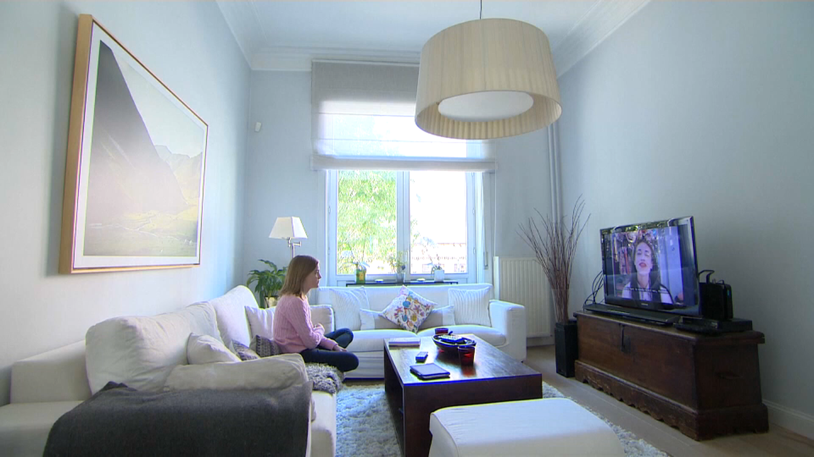Dona que veu la televisió a sa casa