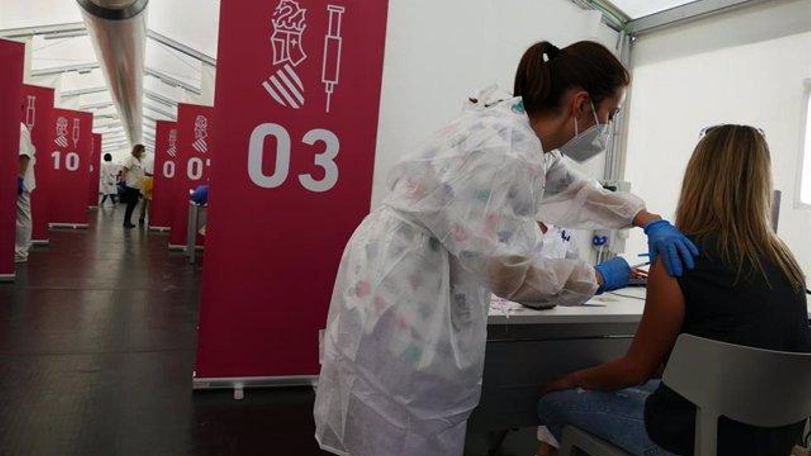 Una sanitària vacuna una dona amb la primera dosi