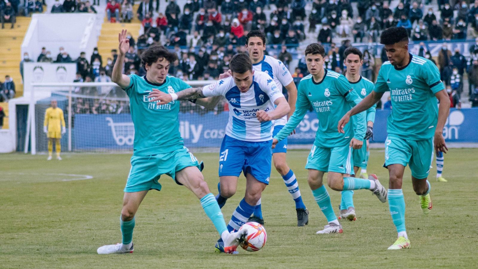Ángel López avança amb el baló davant la pressió de diversos jugadors del Castella