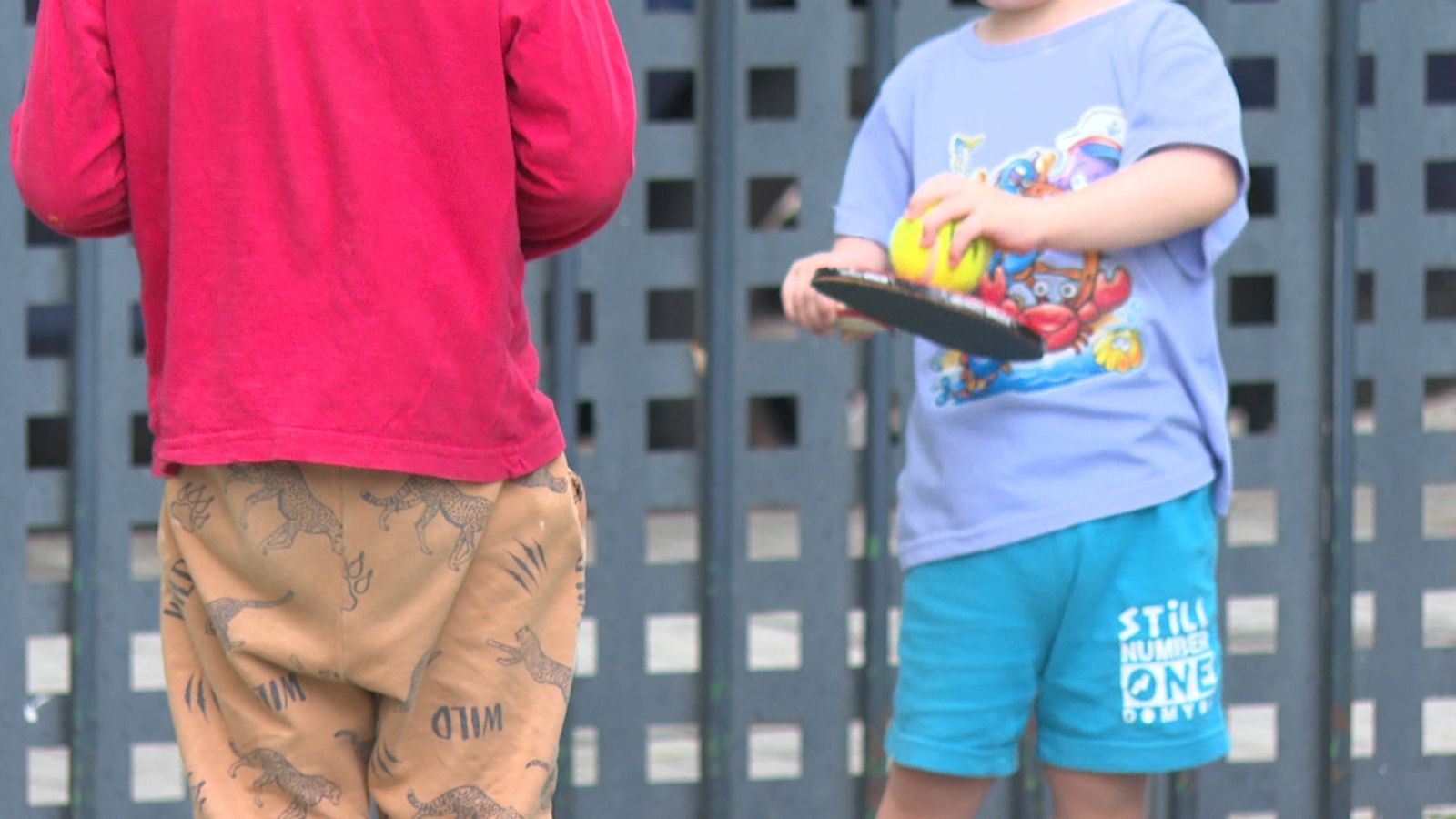 Dos xiquets juguen en el pati d'una escoleta