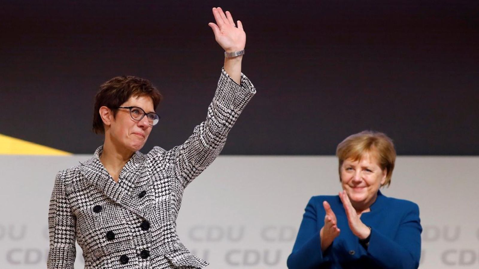 Kramp-Karrenbauer saluda la militància després d'haver sigut triada nova líder de la CDU, amb Merkel de fons