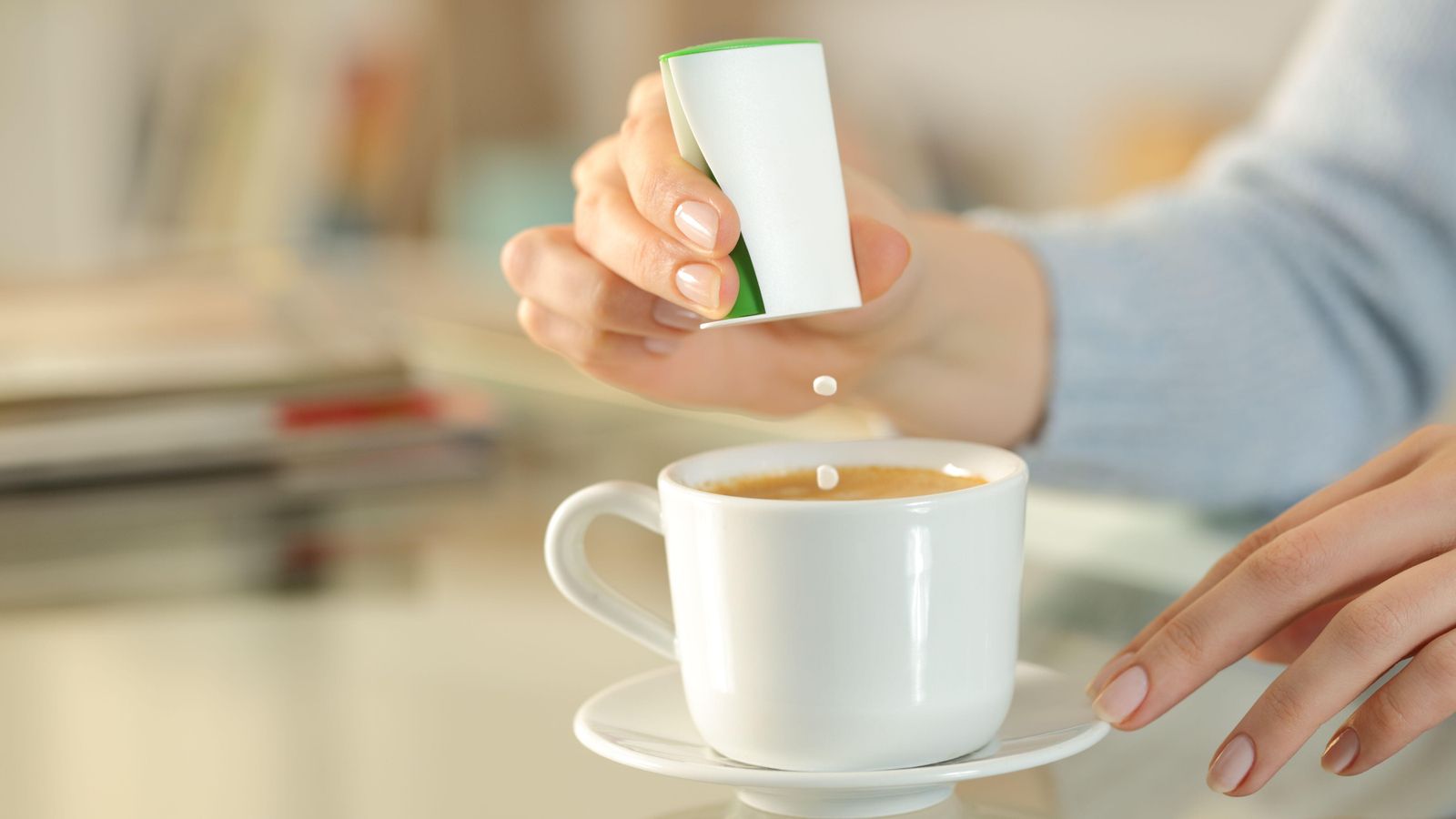 Una dona usa edulcorant en el café