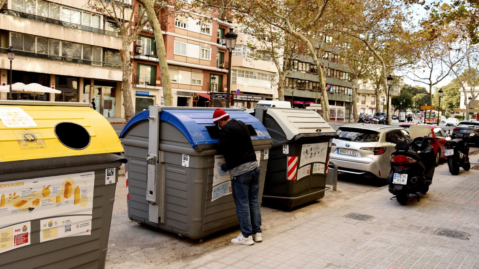 Un home busca en un contenidor a València