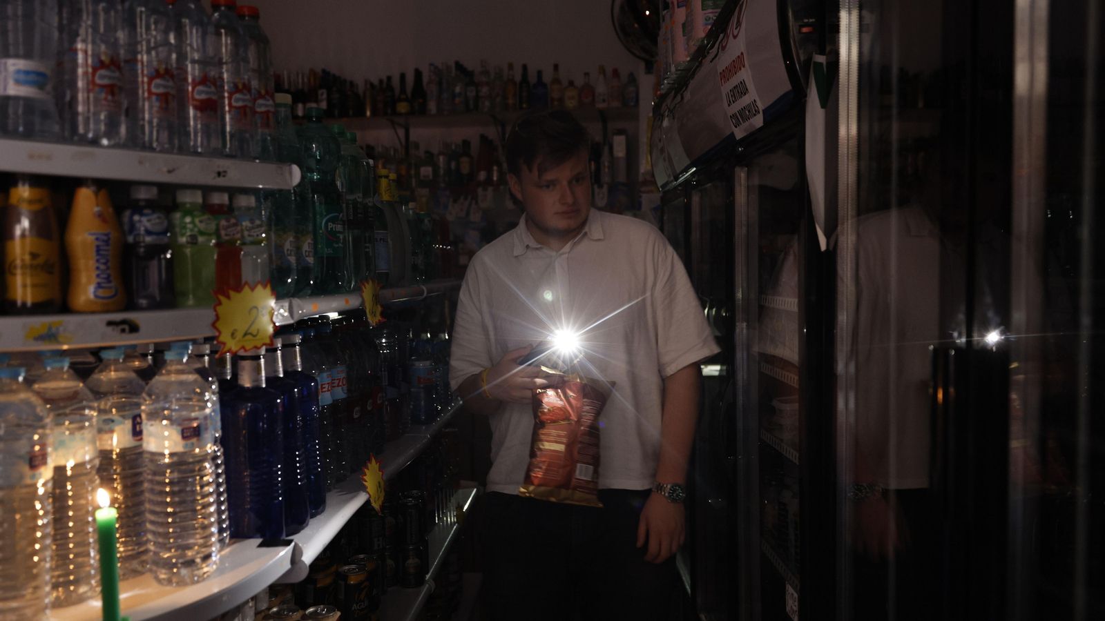 Un jove s'il·lumina amb el telèfon després de l'apagada elèctrica