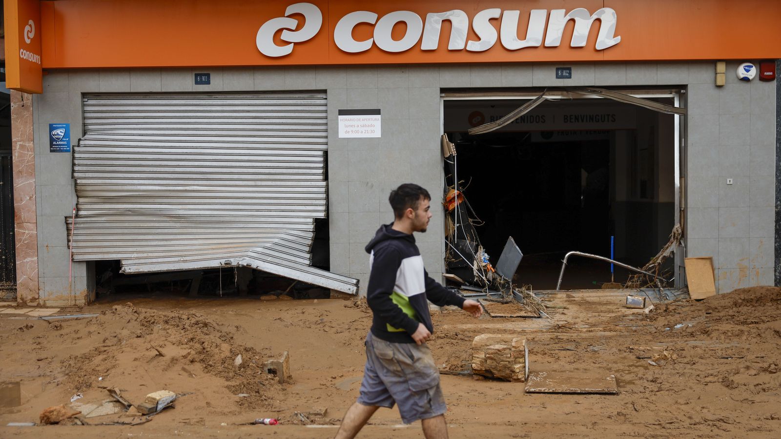 Un veí camina al costat d'un supermercat de Consum afectat a Paiporta
