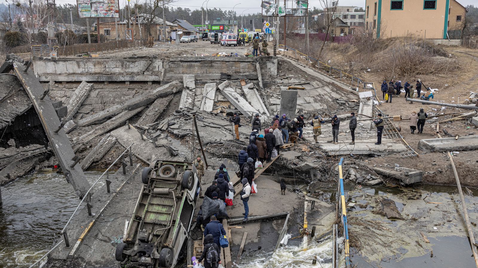Ciutadans ucraïnesos creuen un pont destruït durant una evacuació a la ciutat d'Irpín, als afores de Kíiv
