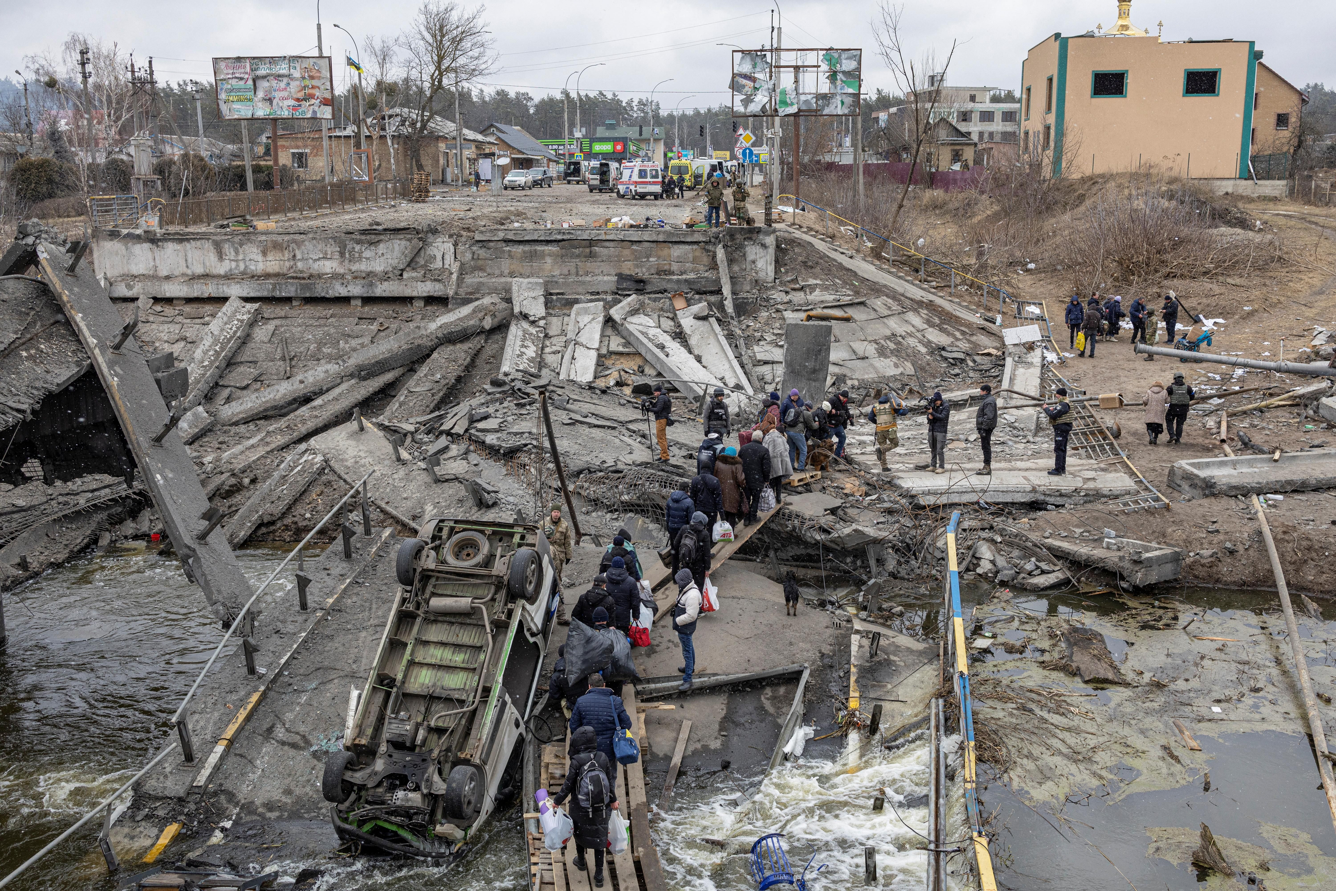 Ciutadans ucraïnesos creuen un pont destruït durant una evacuació a la ciutat d'Irpín, als afores de Kíiv Ciutadans ucraïnesos creuen un pont destruït durant una evacuació a la ciutat d'Irpín, als afores de Kíiv