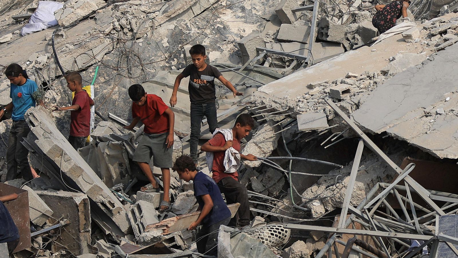 Xiquets caminen per damunt dels enderrocs d'un edifici bombardejat a la Franja de Gaza