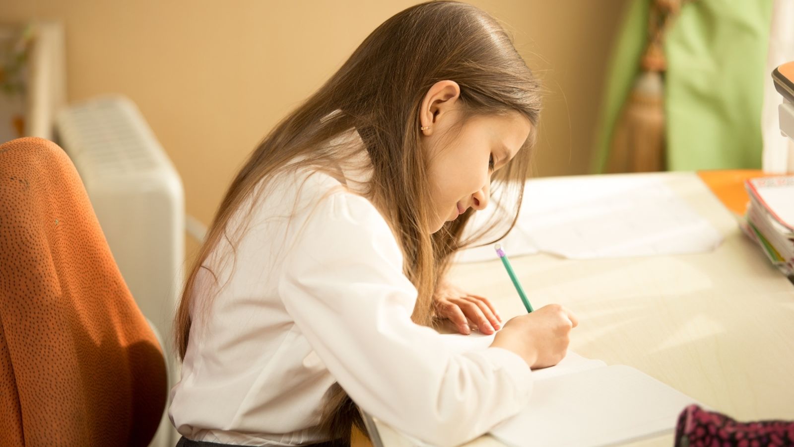 Una xiqueta escriu una carta, en una imatge d'arxiu