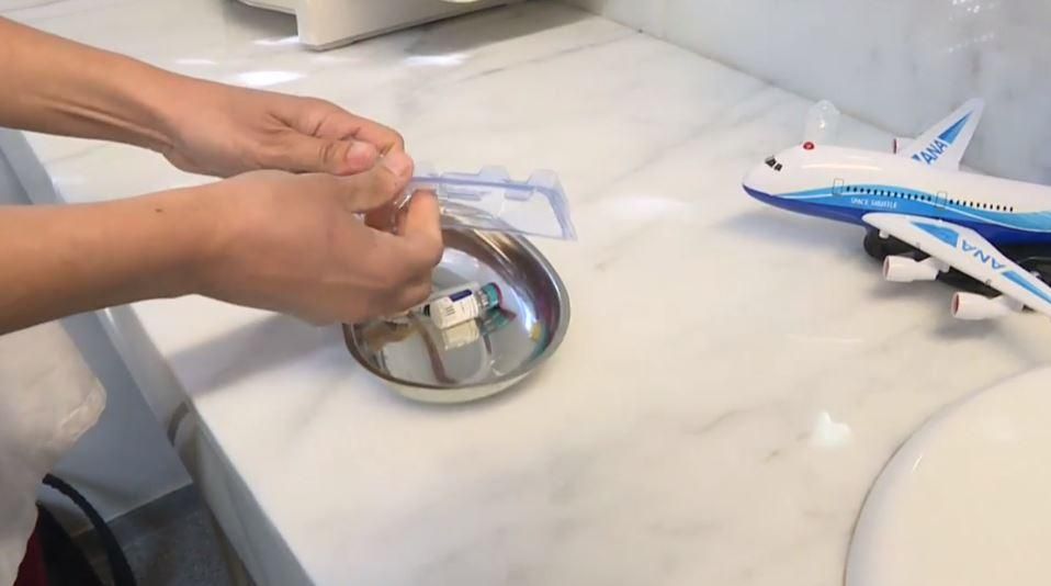 Una infermera prepara una vacuna per a un xiquet Una infermera prepara una vacuna per a un xiquet