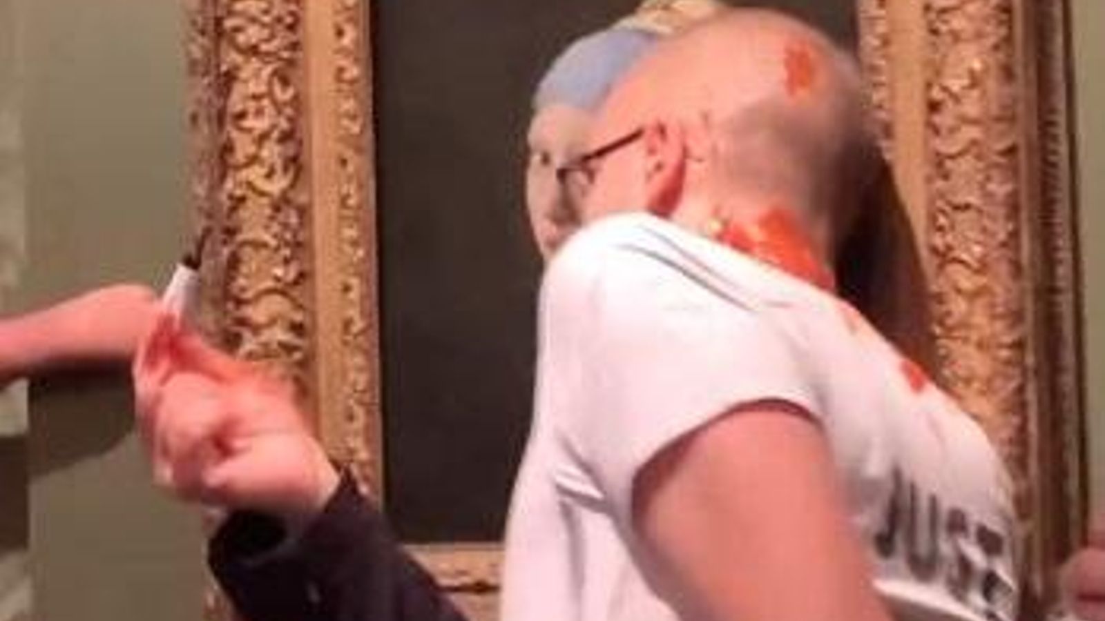 Moment del vídeo difós per l'organització on es veu el retolador i la salsa de tomaca davant el quadre de Vermeer. Moment del vídeo difós per l'organització on es veu el retolador i la salsa de tomaca davant el quadre de Vermeer.