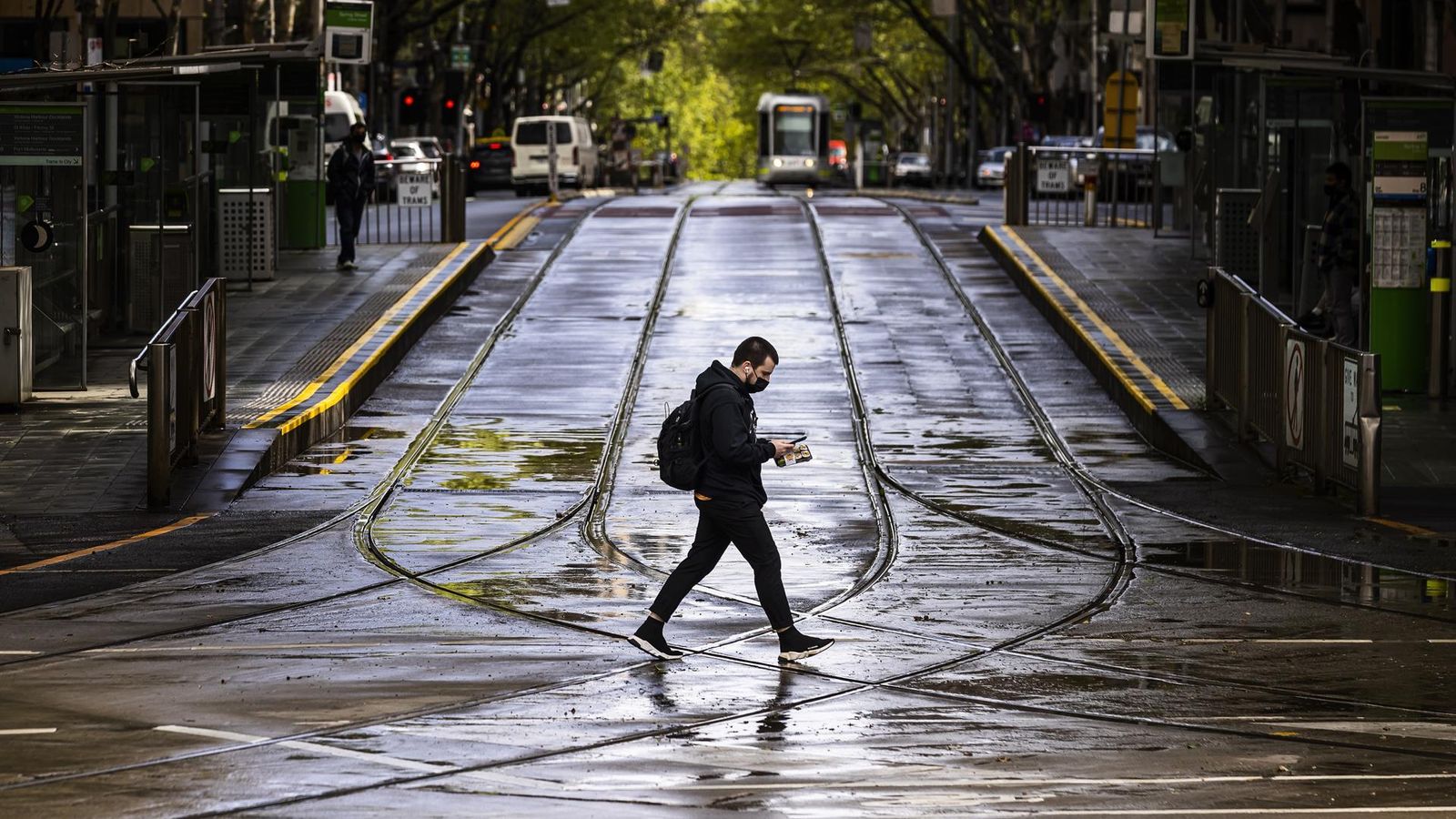 Una persona creua el carrer Collins a Melbourne, Austràlia