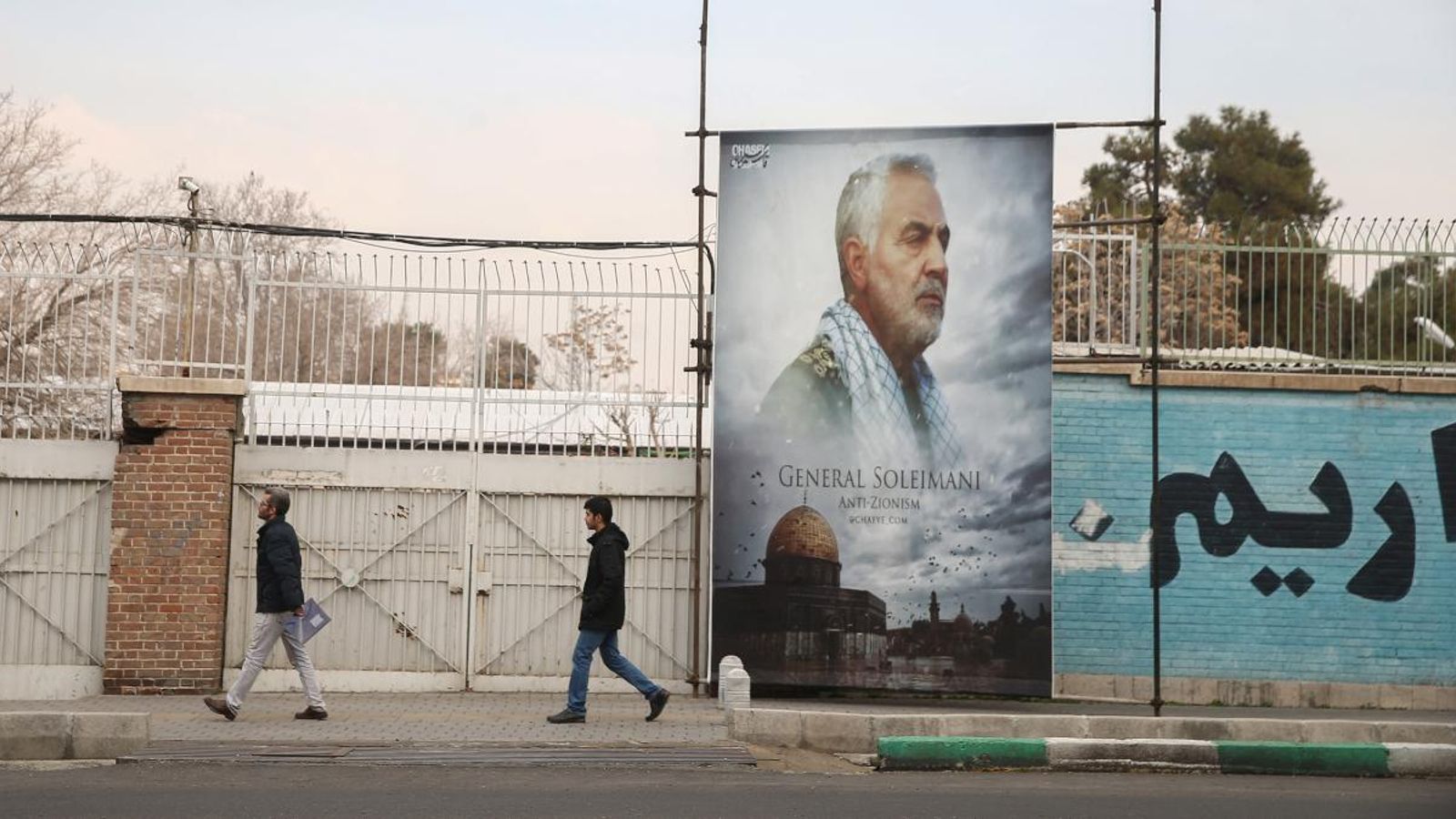 Un grup de persones passa per davant d’una foto de Qassem Soleimani a Teheran