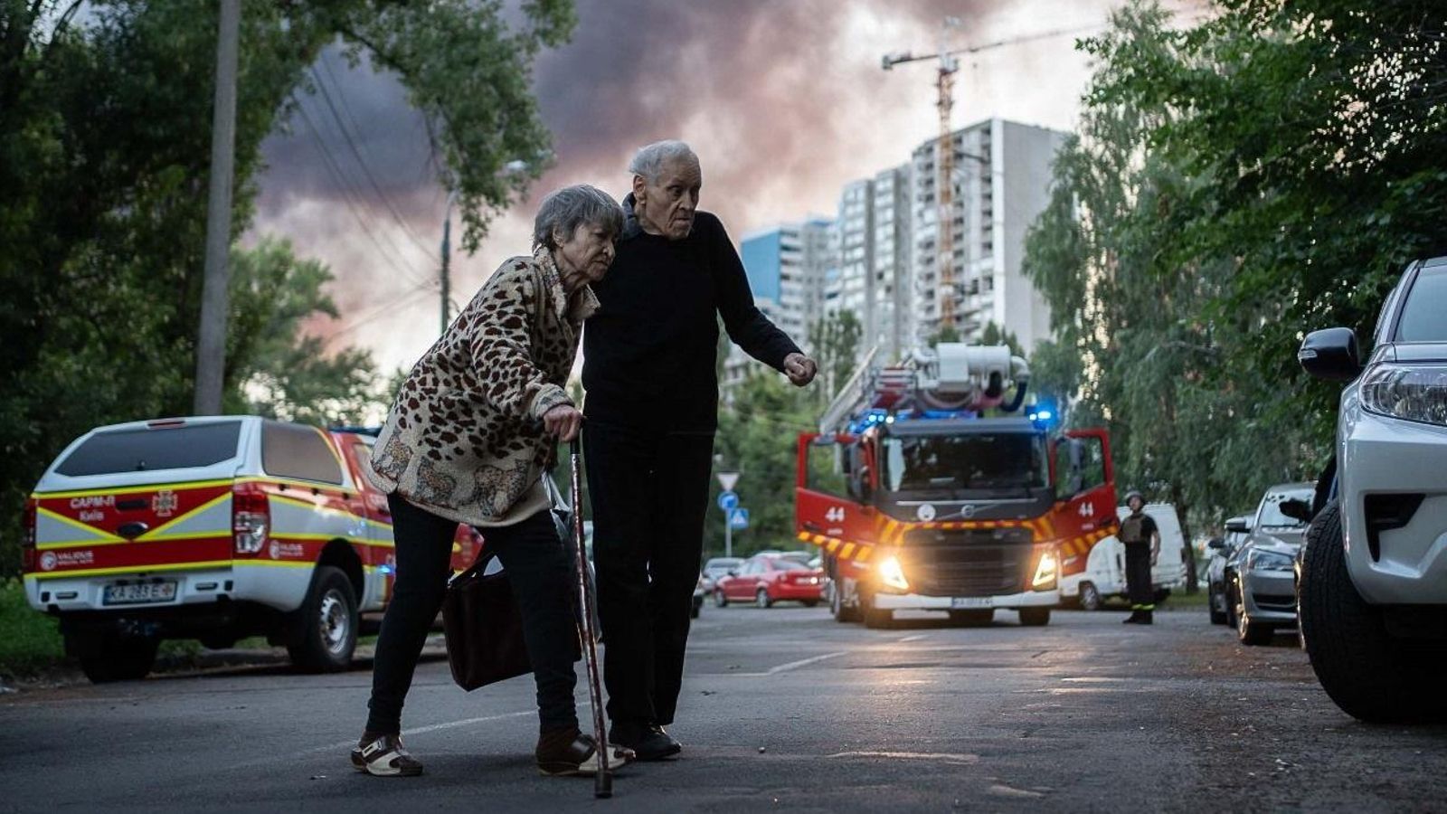 Una parella d'ancians ucraïnesos fuig d'una zona bombardejada pels russos