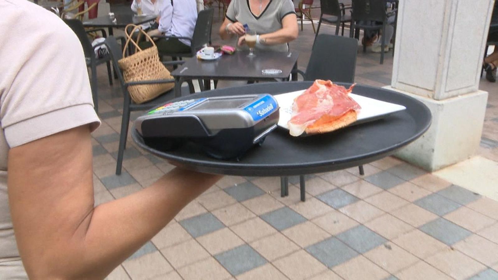 Una cambrera porta una safata amb un datàfon i una torrada