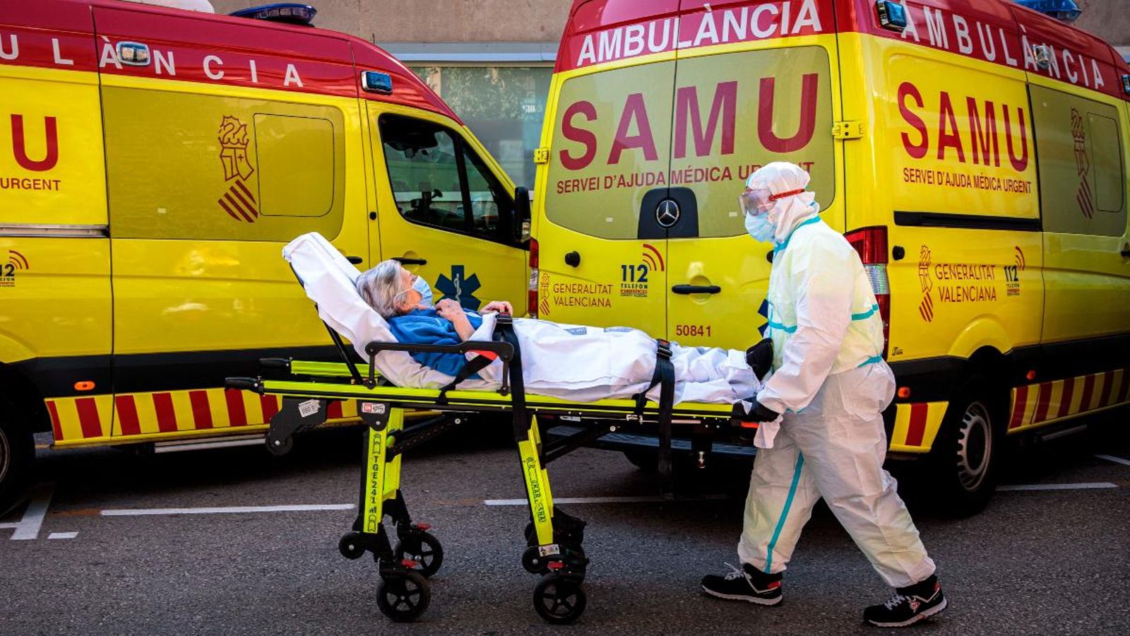 Un sanitari trasllada a un pacient d'una ambulància a urgències de l'Hospital Clínic de València