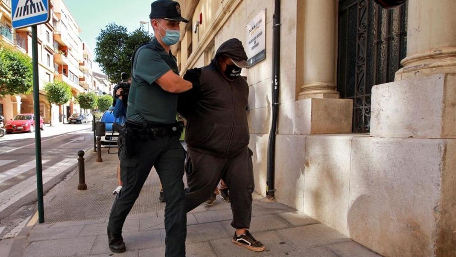 Un agent de la Guàrdia Civil trasllada a un dels deu detinguts al jutjat