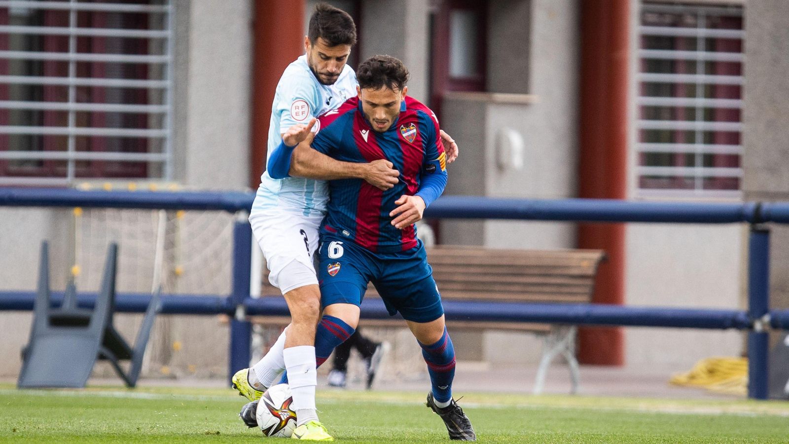 Un jugador de l'Atlètic Llevant i un altre de La Nucia disputen un baló