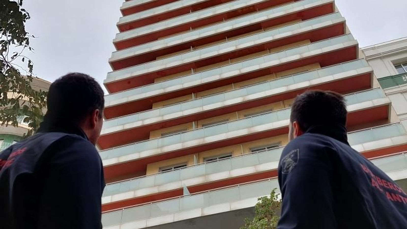 Dos bombers revisen els materials de les façanes dels edificis alts