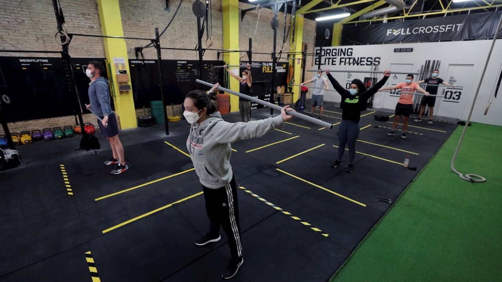Un grup de persones durant un entrenament de crossfit a porta tancada amb la mascareta obligatòria