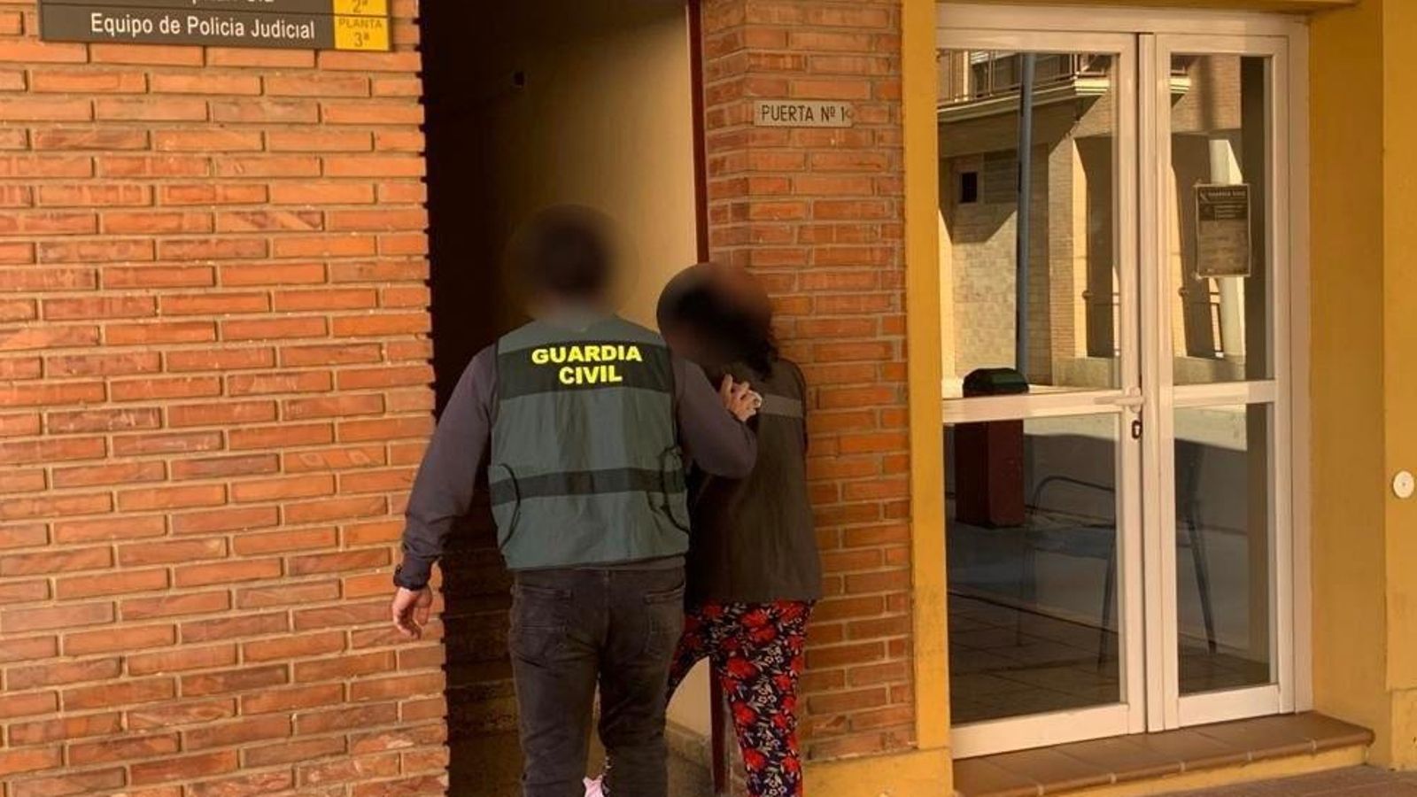 Un agent de la Guàrdia Civil amb una de les persones detingudes