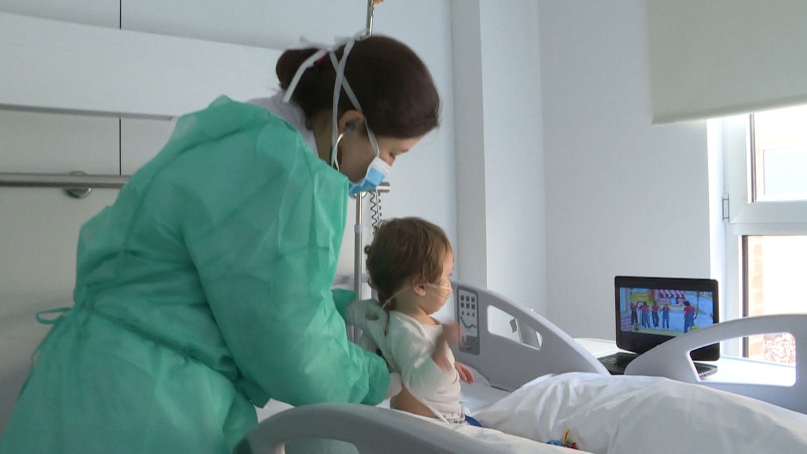 Una treballadora d'un centre de salut atén un xiquet amb mascareta