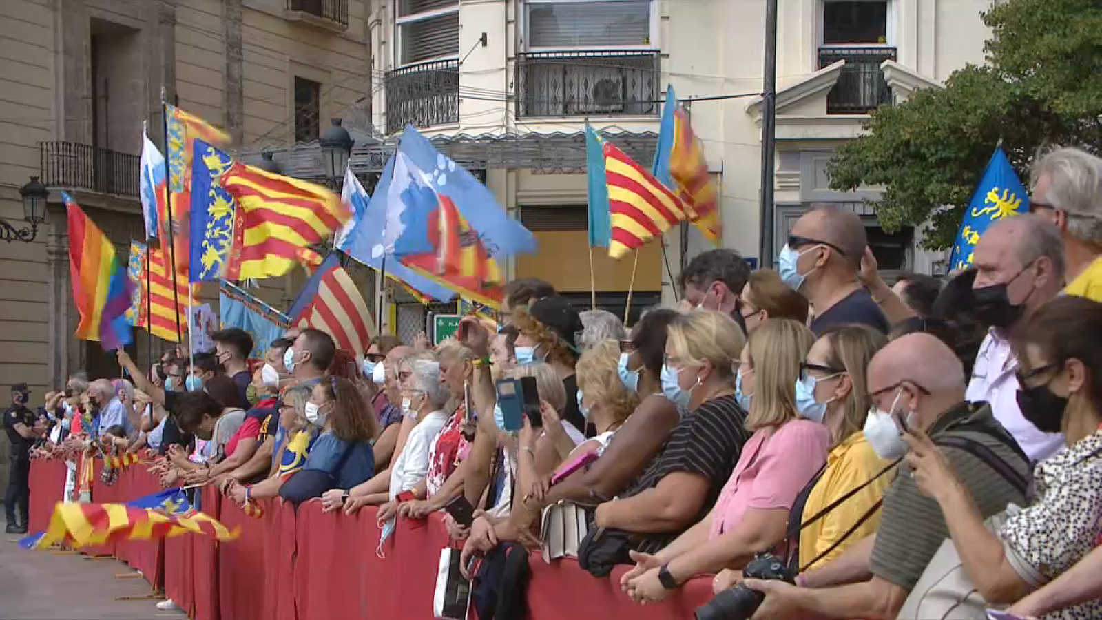 Valencians i valencianes amb banderes durant la celebració de la processó cívica