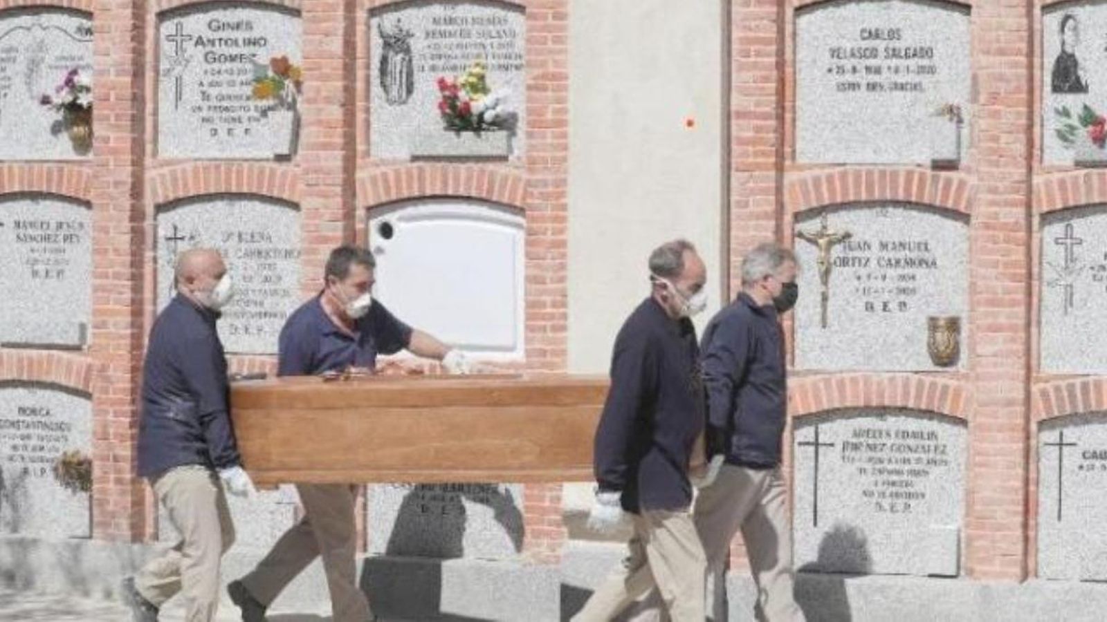 Uns operaris traslladen un fèretre al cementeri el passat mes d'abril