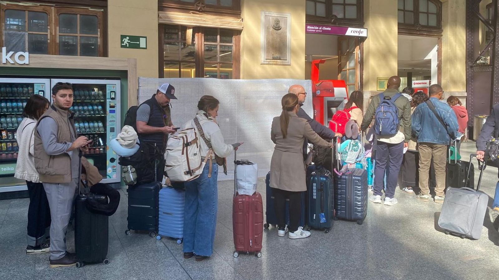 Els viatgers, proeveïts en molts casos de maletes, fan cua en l'Estació del Nord de València per a canviar els bitllets per a viatjar a Catalunya