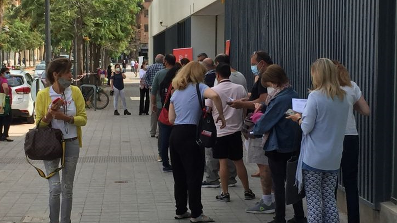 Aquest dimarts de vesprada, a la ciutat de València, persones esperen rebre la vacuna de Pfizer, al barri de Benicalap