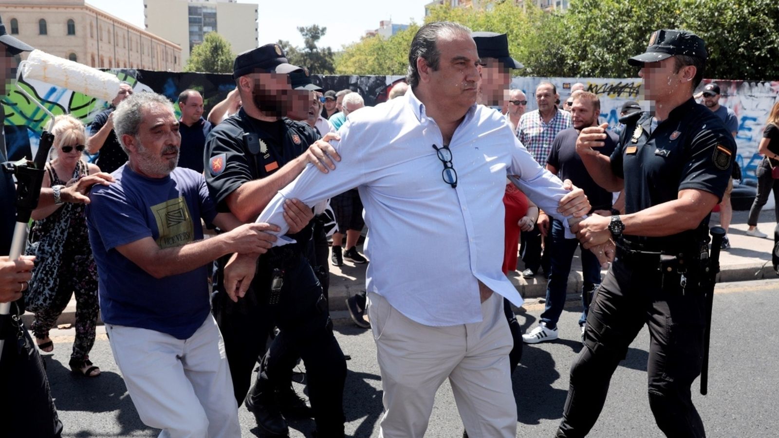 Juan García Sentandreu és apartat per agents de la policia després d'intentar pintar de blanc el mur