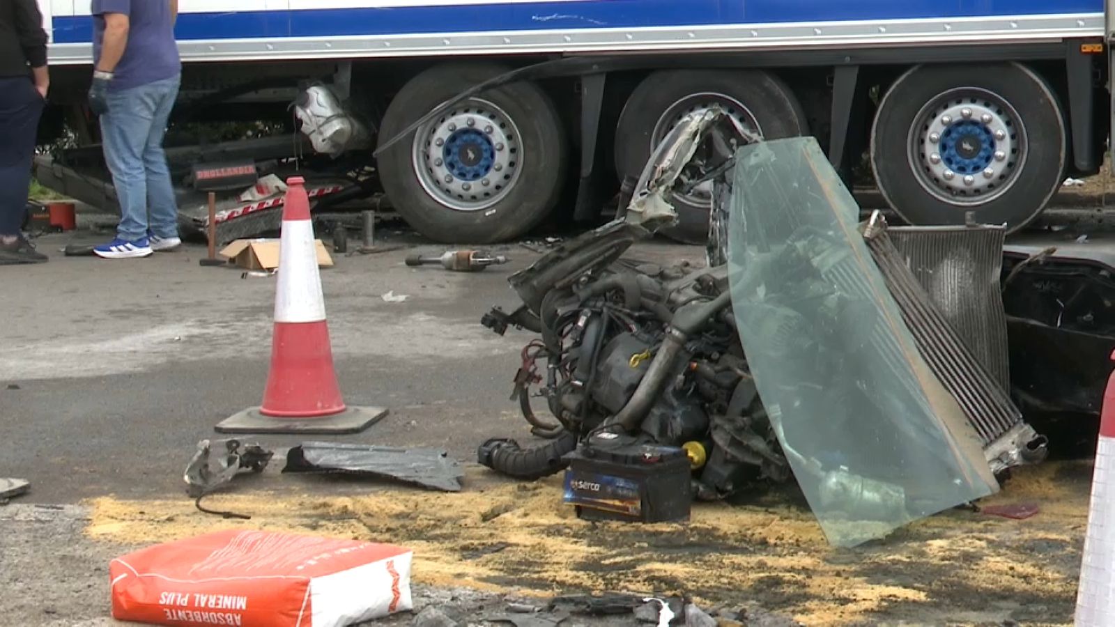 Les restes del cotxe accidentat, encastades davall del camió aparcat a la gasolinera