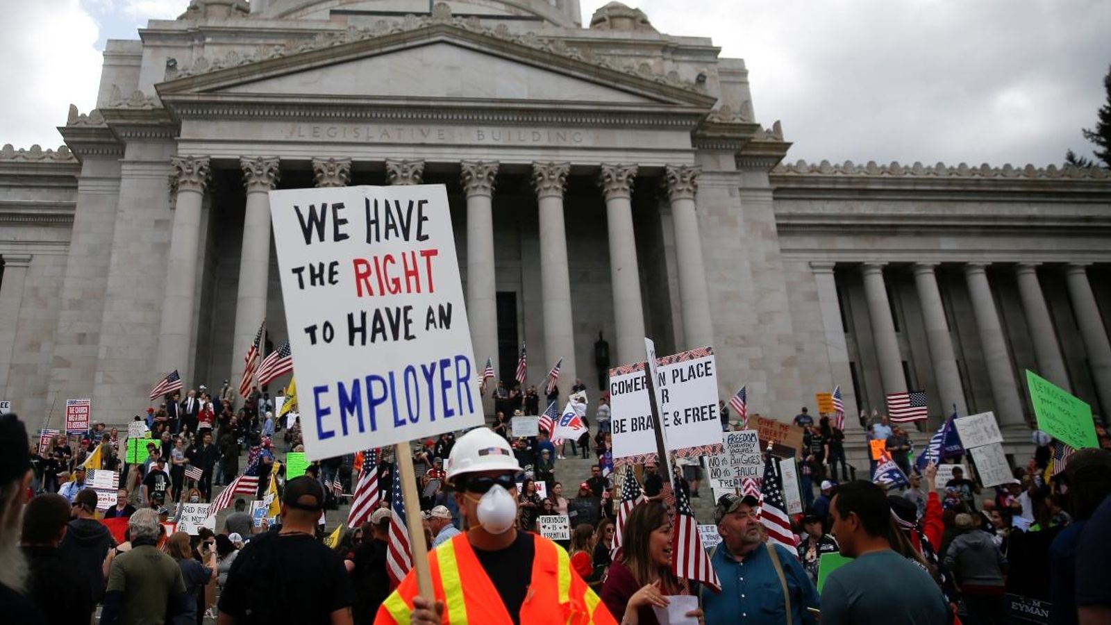Desenes de persones protesten aquest diumenge contra les mesures de confinament a Washington