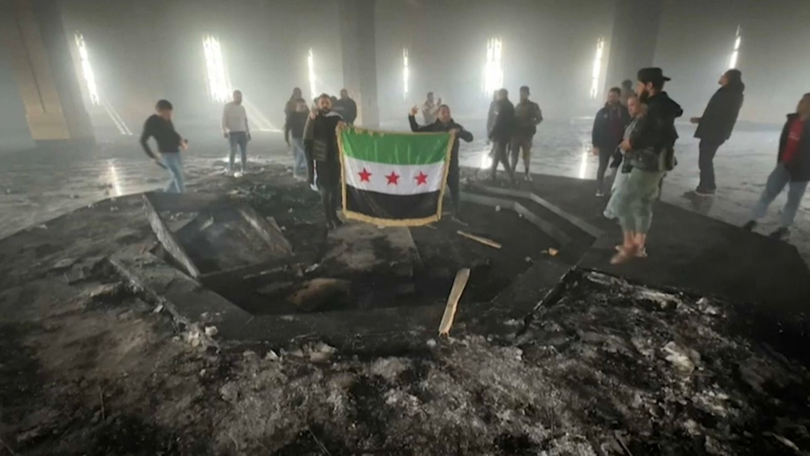 Homes armats posen davant les cendres de la tomba de Hafiz al-Assad, l'expresident de Síria i pare de l'exdictador, Bashar al-Assad