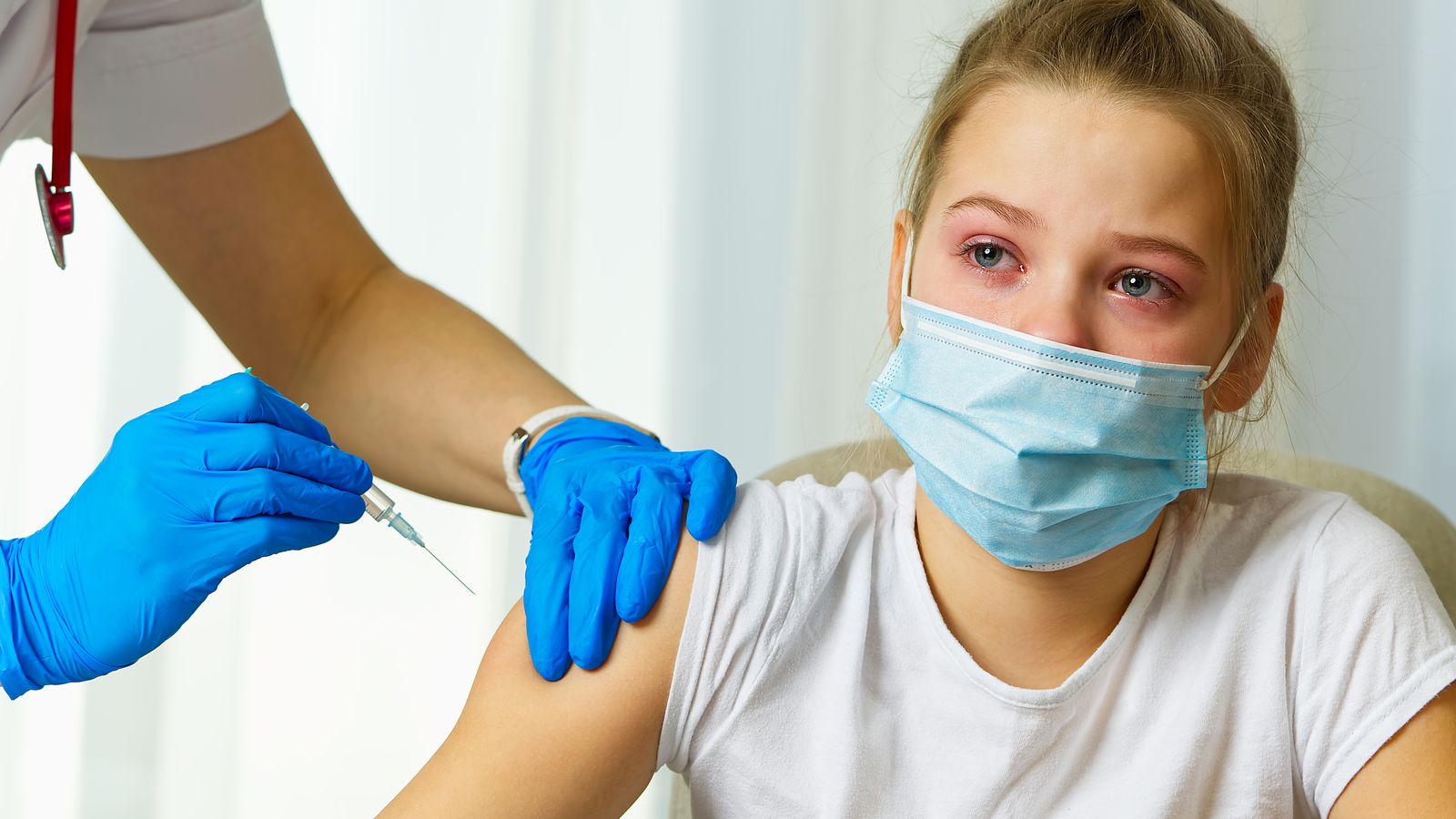 Una xiqueta amb mascareta rep una vacuna