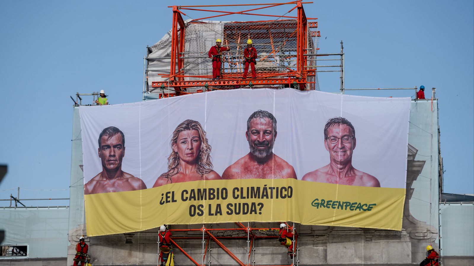 Els candidats a la presidència del govern espanyol en la lona que ha desplegat Greenpeace en la Porta d'Alcalà de Madrid
