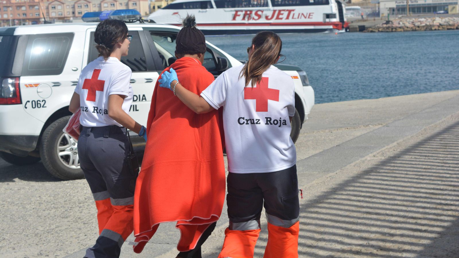 Imatge d'arxiu de voluntariat de la Creu Roja atenent a una persona migrant