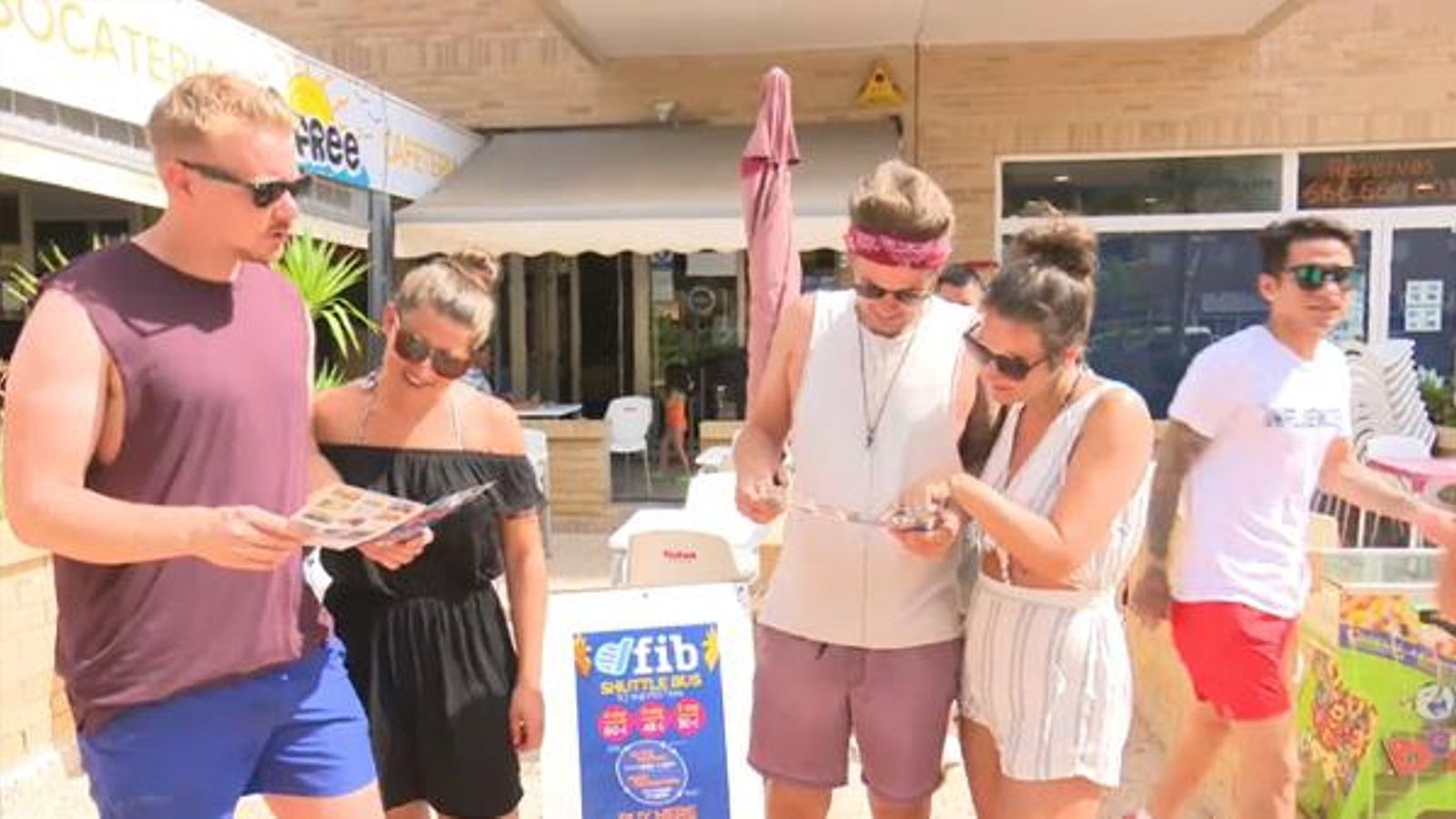 Un grup de joves anglesos consulta els horaris del bus per a anar a Benicàssim