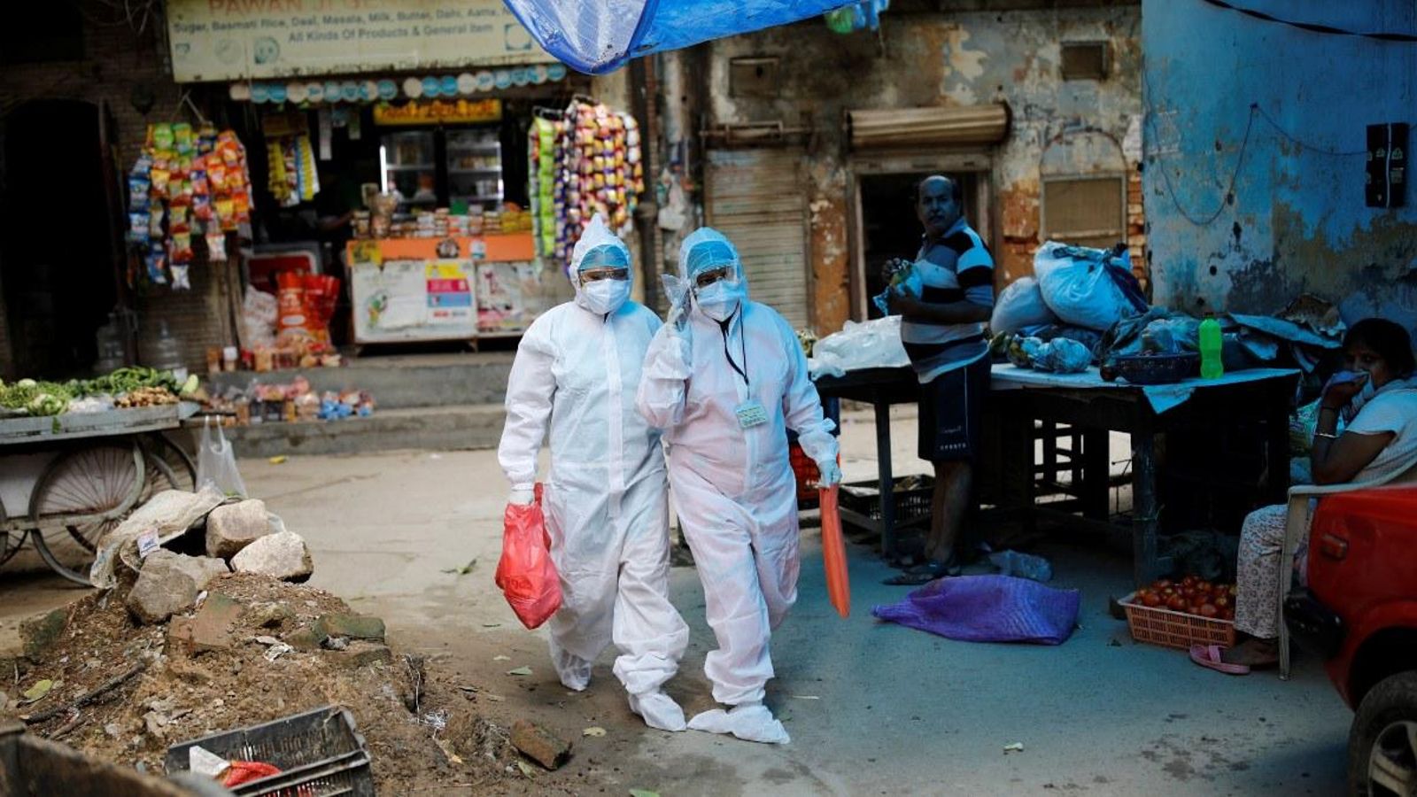 Dos sanitaris recorren els carrers de Nova Delhi, a l'Índia, per a atendre a persones amb símptomes de Covid-19